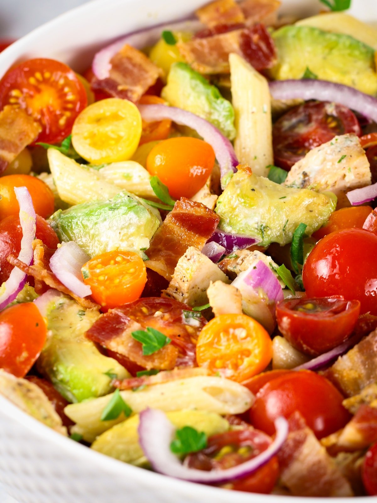 An eye-level close-up bowl of BBQ Chicken Bacon Ranch pasta salad.