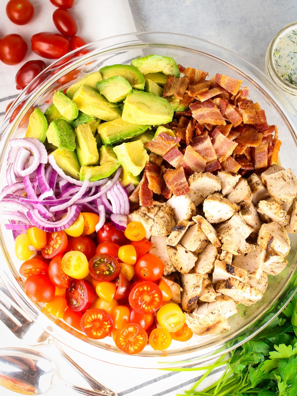 A large glass bowl with ingredients for BBQ Chicken Bacon Ranch pasta.