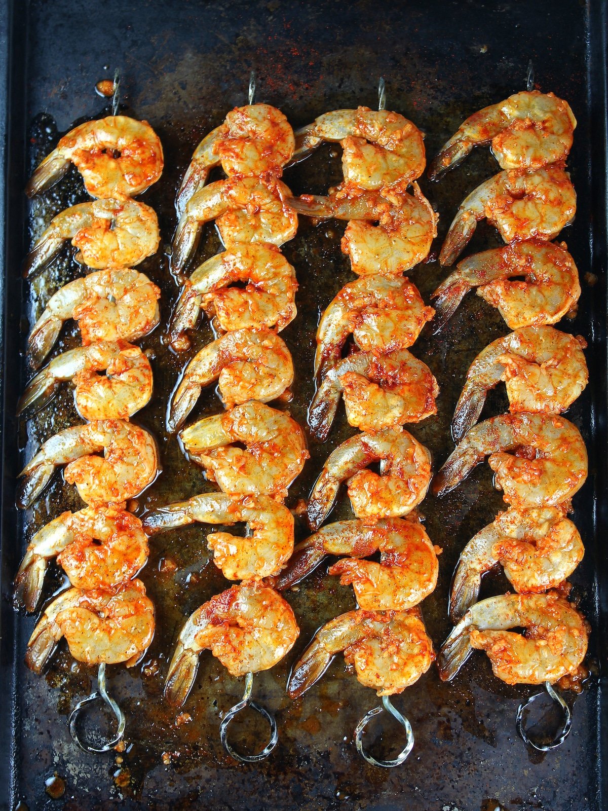 Skewered shrimp on a cookie sheet ready to grill.