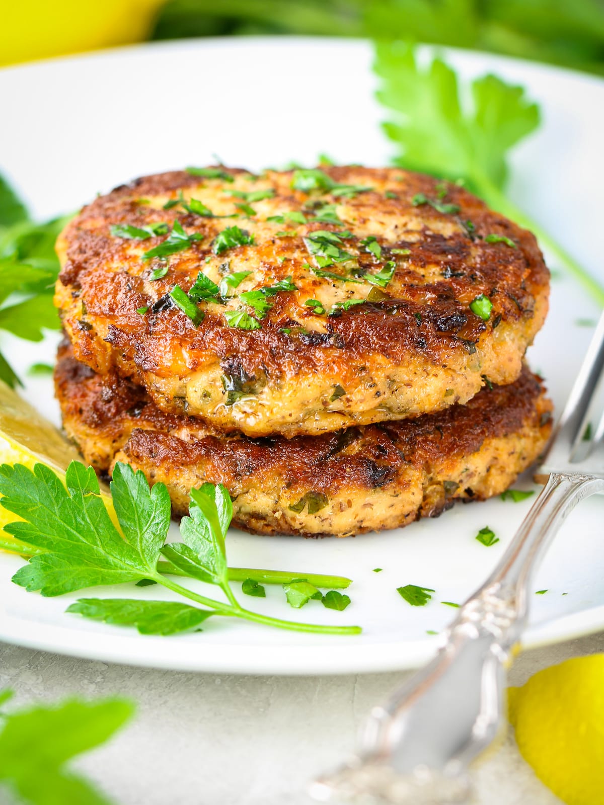 Two pan-fried salmon patties stacked on a plate.