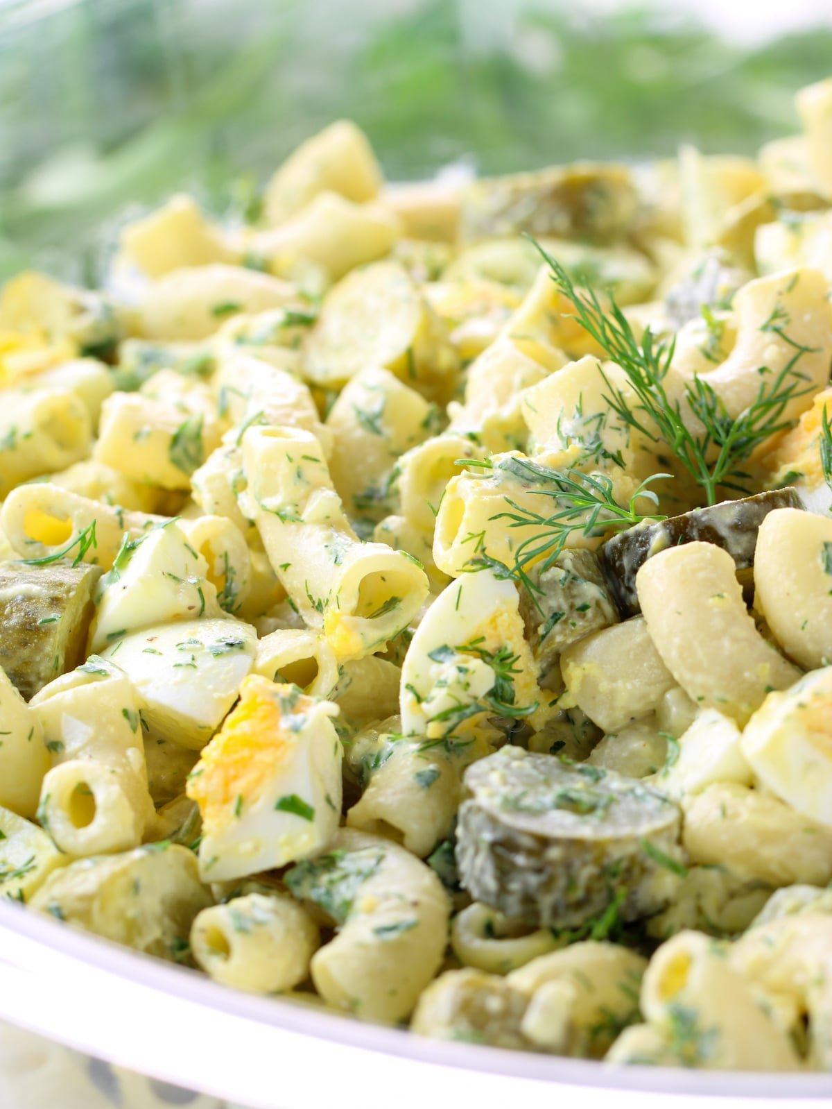 A large glass bowl of pasta salad.