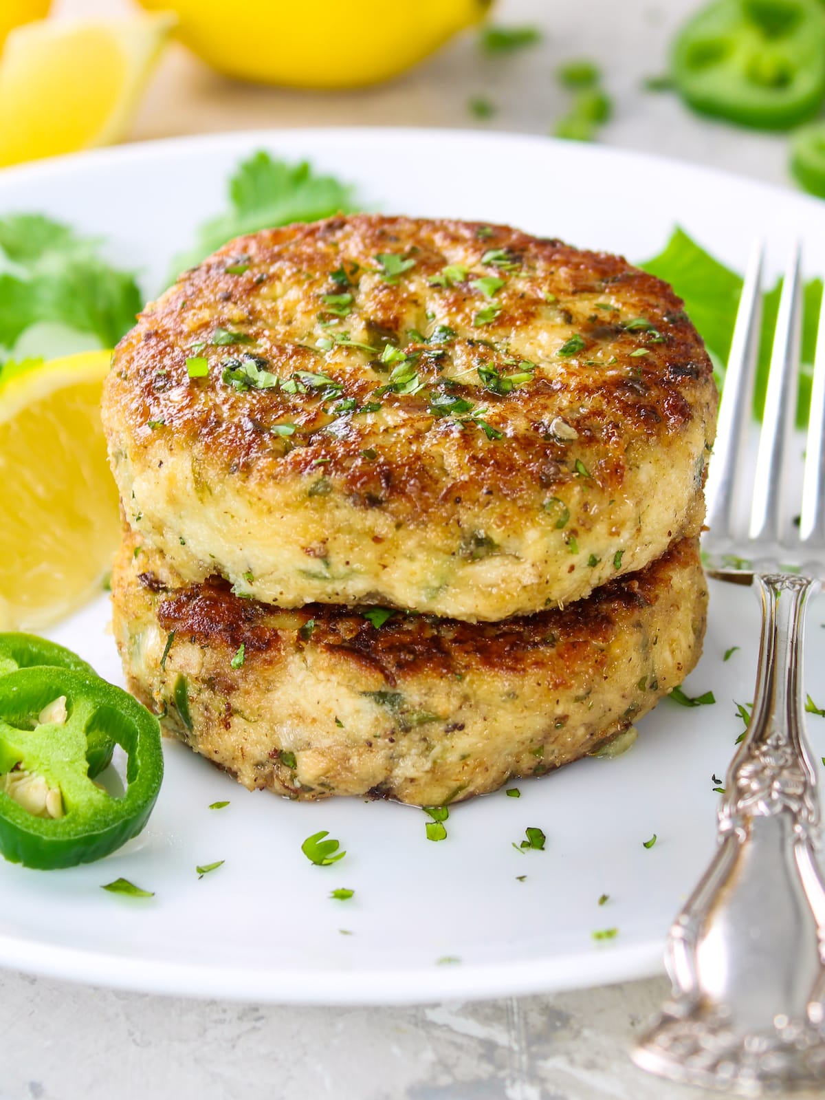 Two Tuna Patties stacked on top of each other on a plate.