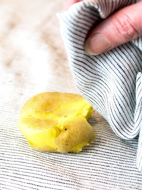 A baby Yukon gold potato on a napkin smashed.