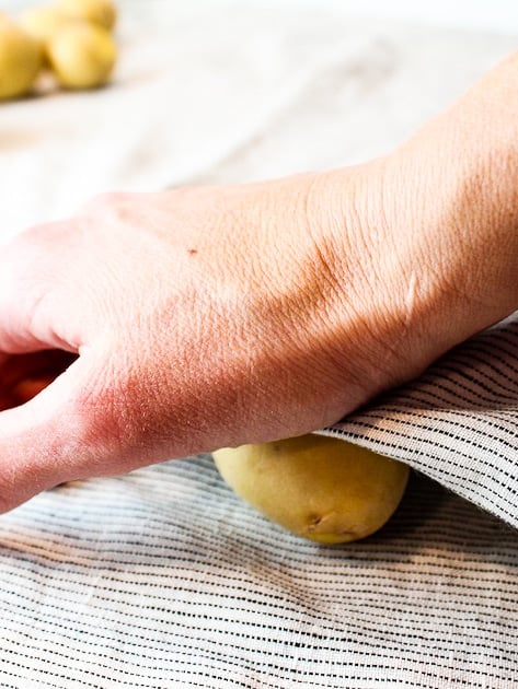 A baby Yukon gold potato on a napkin to smash