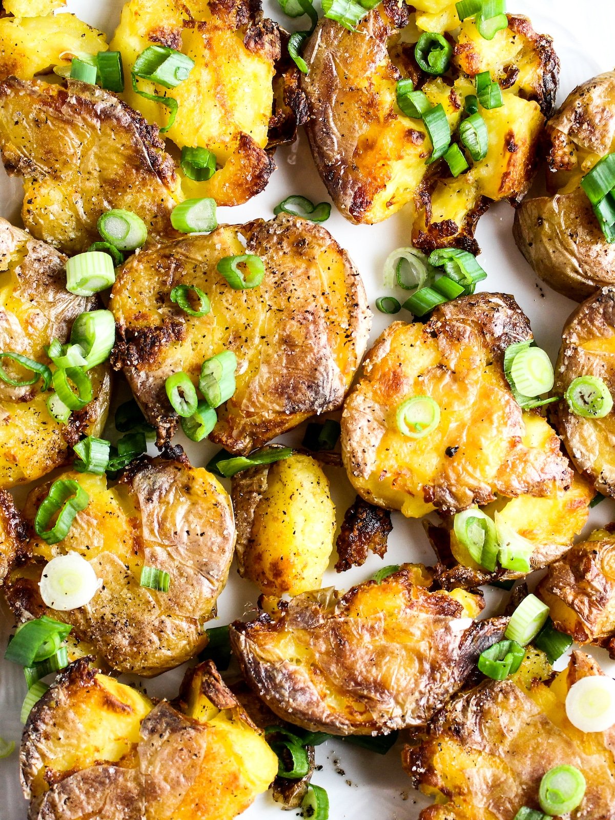 Yukon gold potatoes smashed and roasted on a baking sheet.