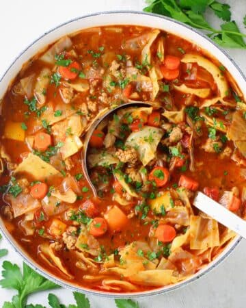 A pot off cabbage roll soup with a large spoon.