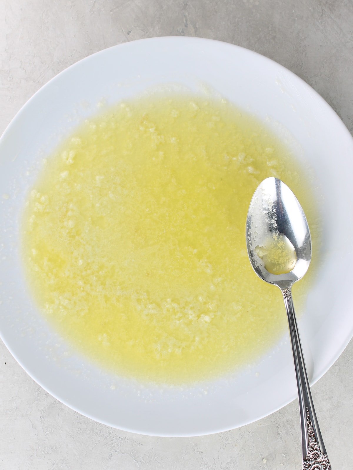 Melted butter, lemon and garlic on a plate.