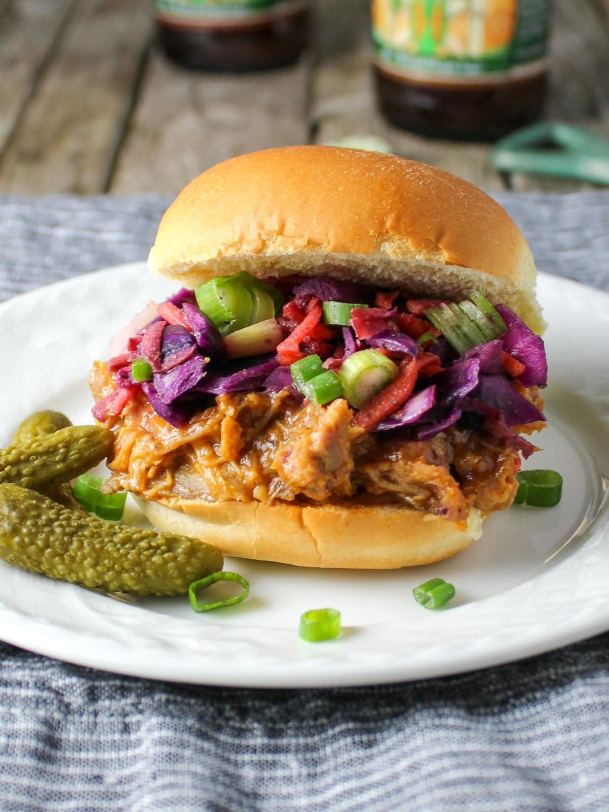 Appetizer recipes - BBQ Pulled Pork Sliders with Tangy Warm Cabbage Slaw on a plate with pickles.