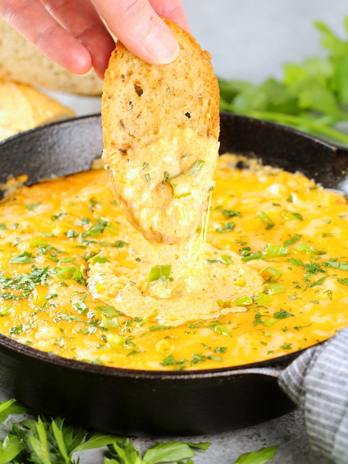 Easy Appetizers - Cheesy Buffalo Shrimp Dip with a person dipping bread into it.