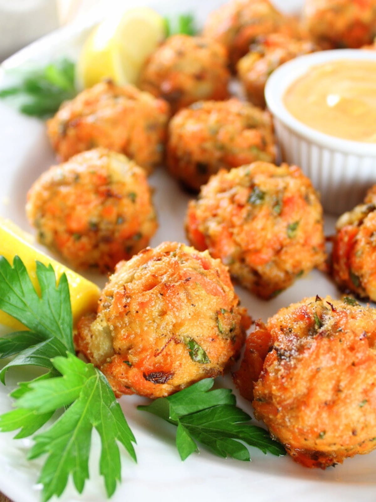 Mini Salmon Cakes on a platter with dipping sauce.