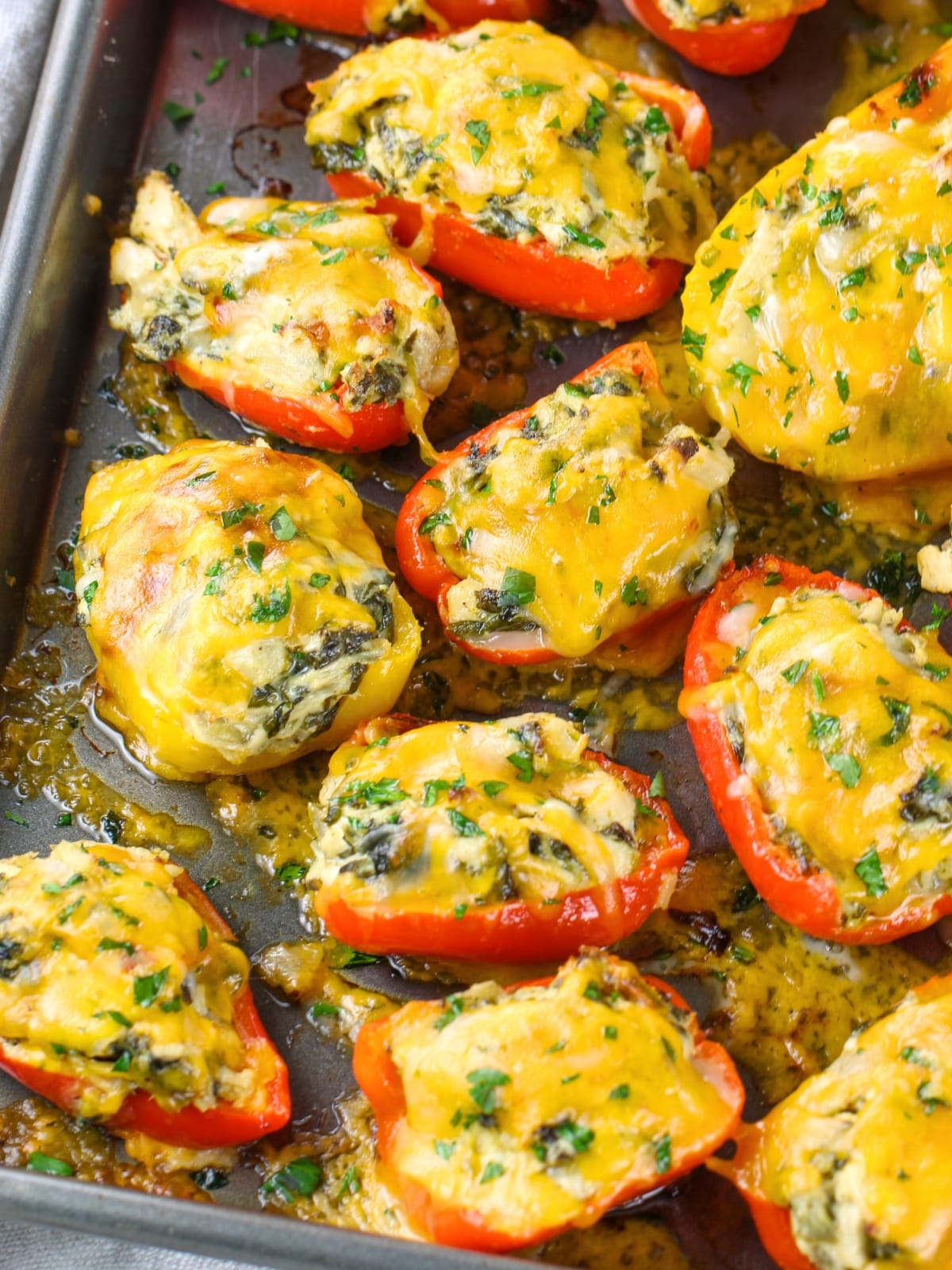 Spinach Artichoke Chicken Stuffed Peppers cooked on a baking sheet.