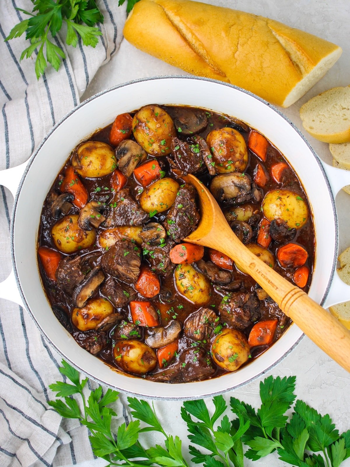 A large pot of beef stew with sour dough bread.