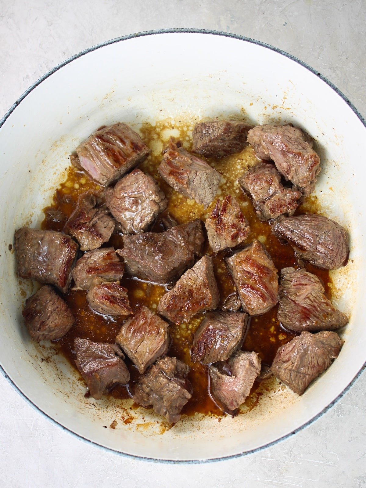 Searing chunks of beef chuck roast in a large pot.