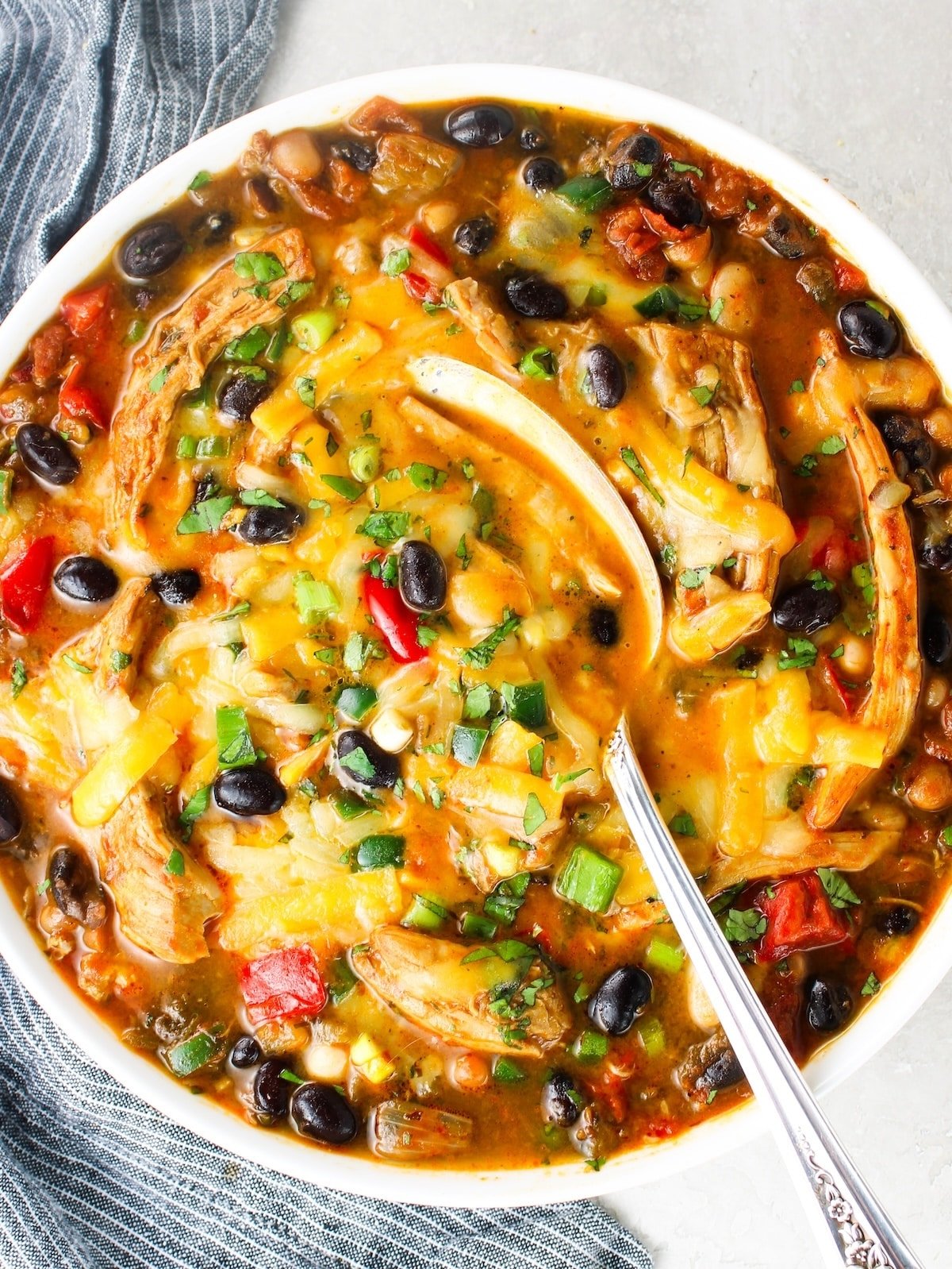 A bowl of Mexican flavored soup with toppings added.