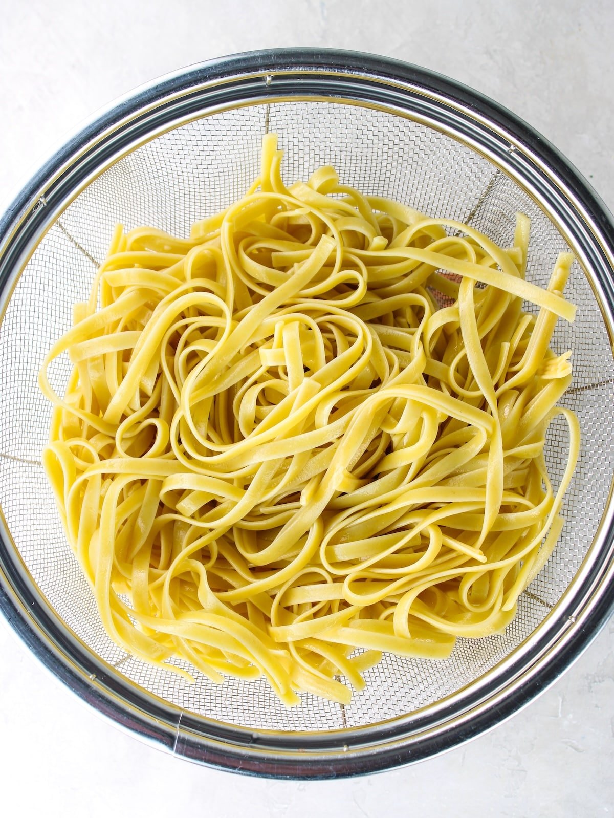 Fettuccine pasta drained in a colander.