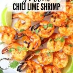 A Pinterest pin of skewered and Grilled Chili Lime Shrimp on a platter.