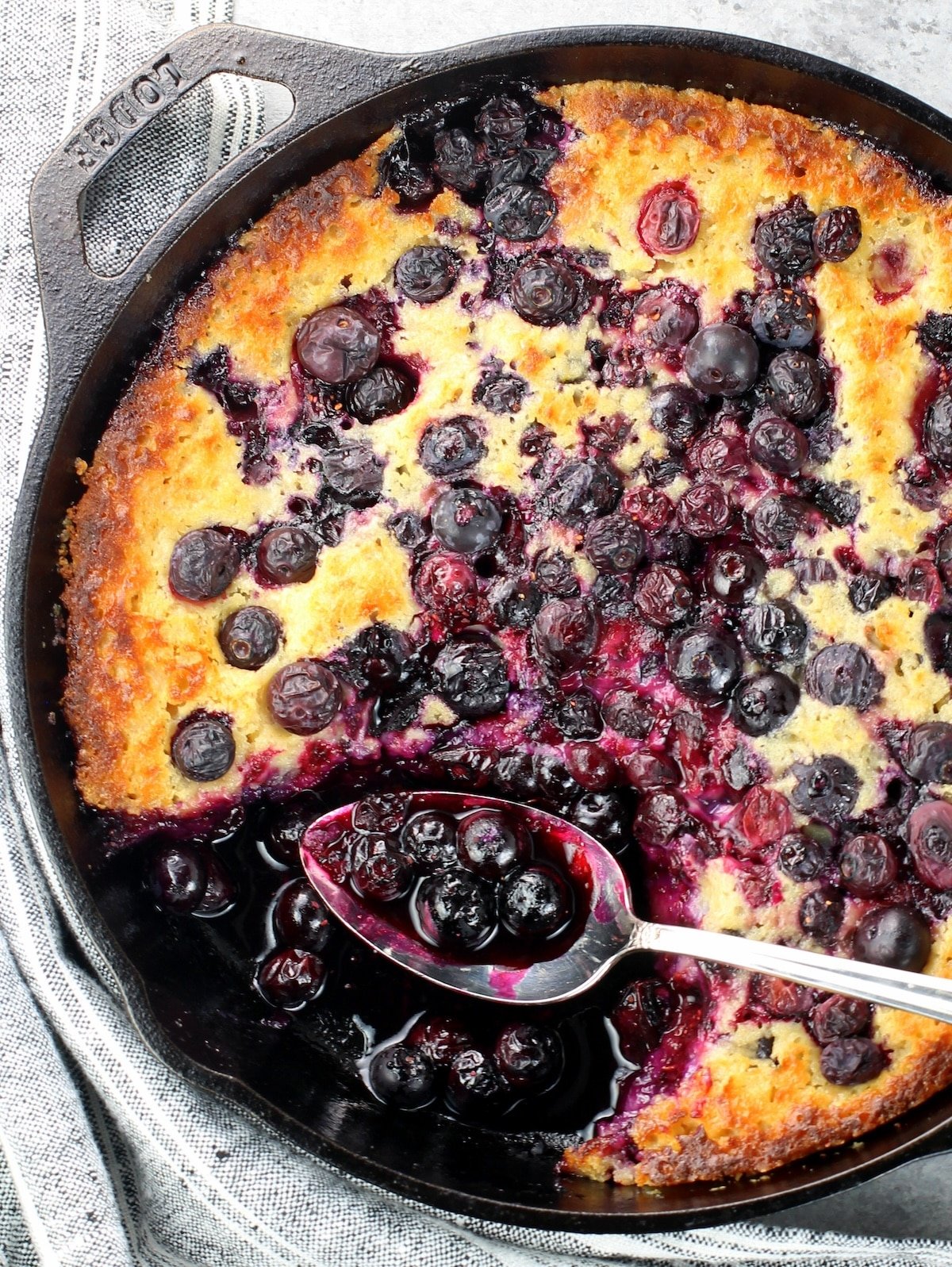 A photo of half a pan of baked blueberry cobbler.