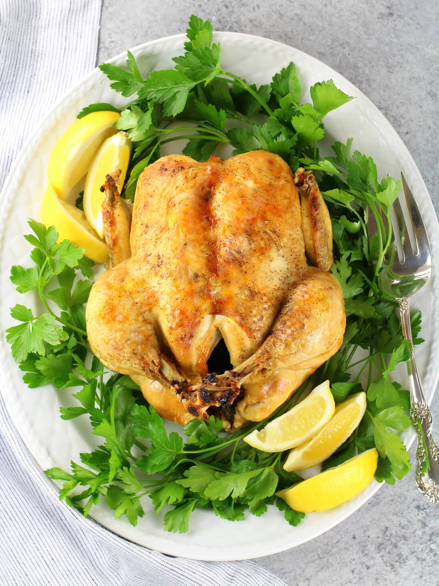 A chicken cooked and browned on a platter.