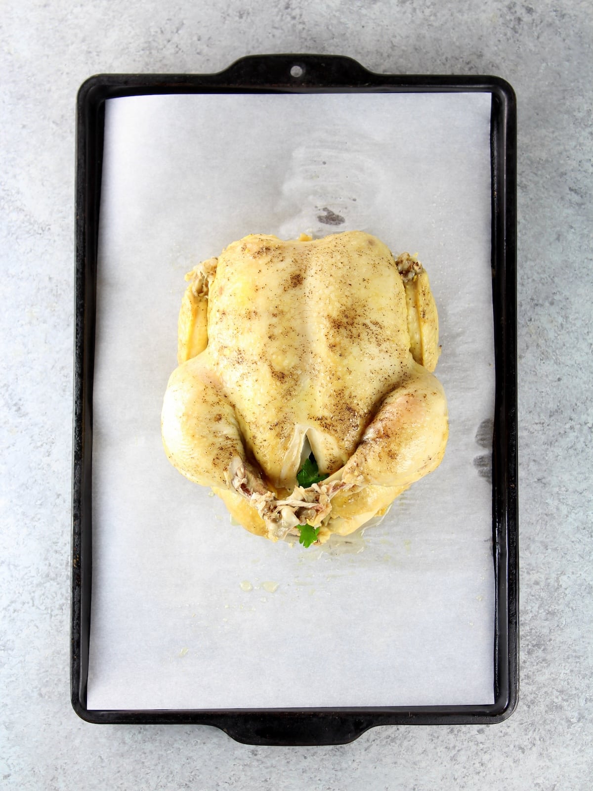 Whole chicken recipe - cooked chicken on a baking sheet.