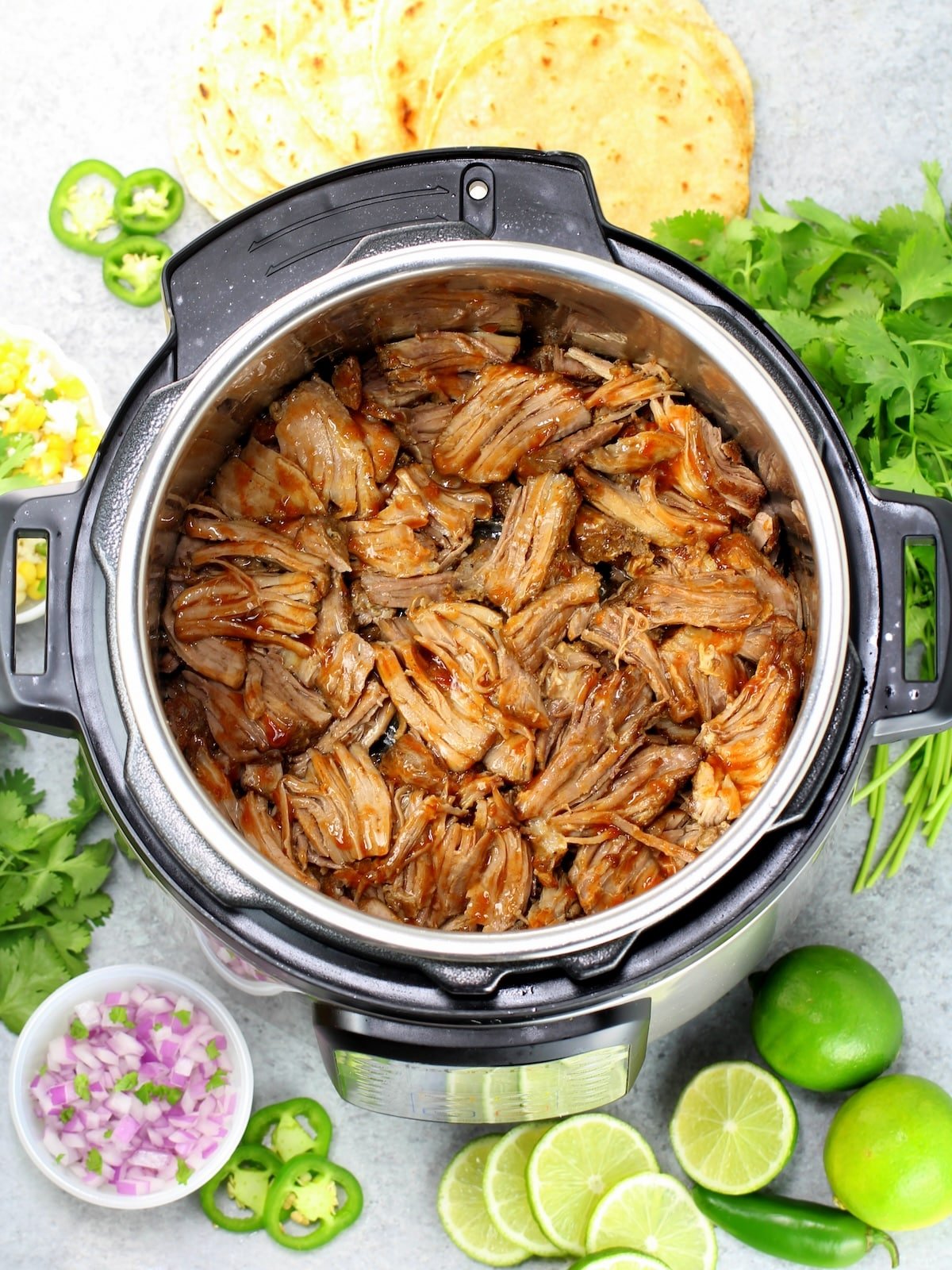 Instant pot full of cooked pork carnitas meat.