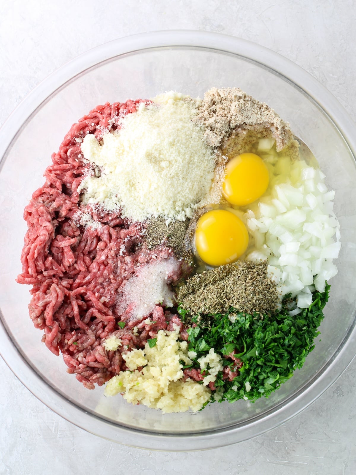 A large glass mixing bowl with the ingredients before combining.