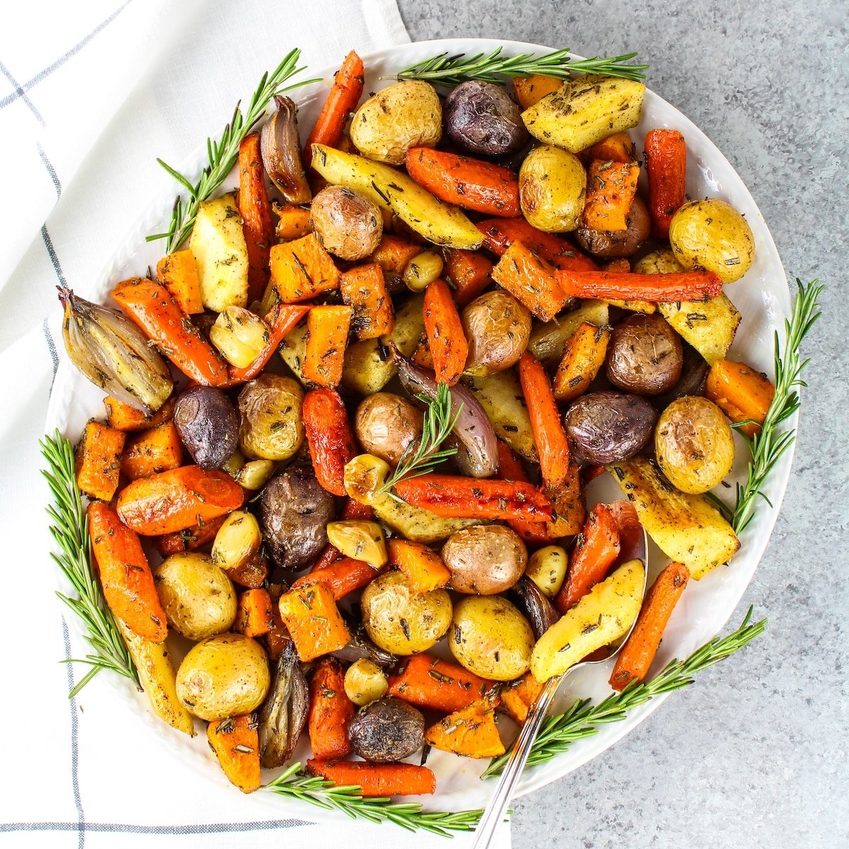 Lots of roasted root vegetables on platter.