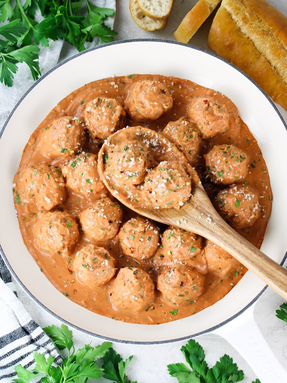 A pan with baked meatballs in pasta sauce.