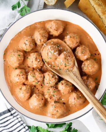 Homemade meatballs in sauce with parmesan cheese.