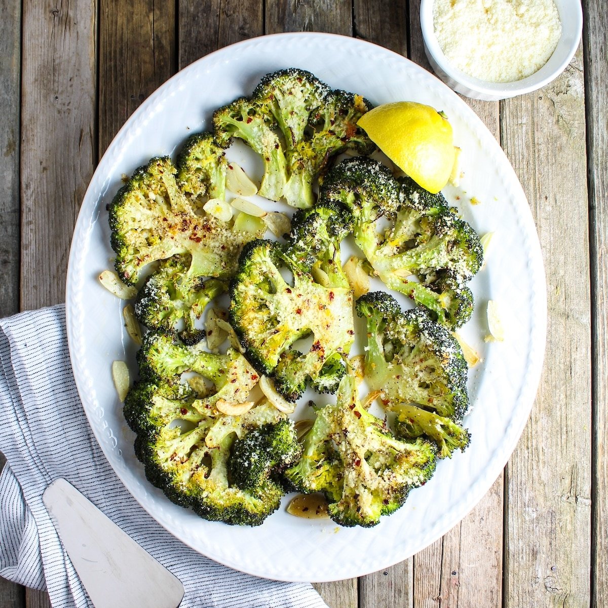 A 1200x1200 photos of Roasted Parmesan Broccoli with garlic and red chili pepper flakes.