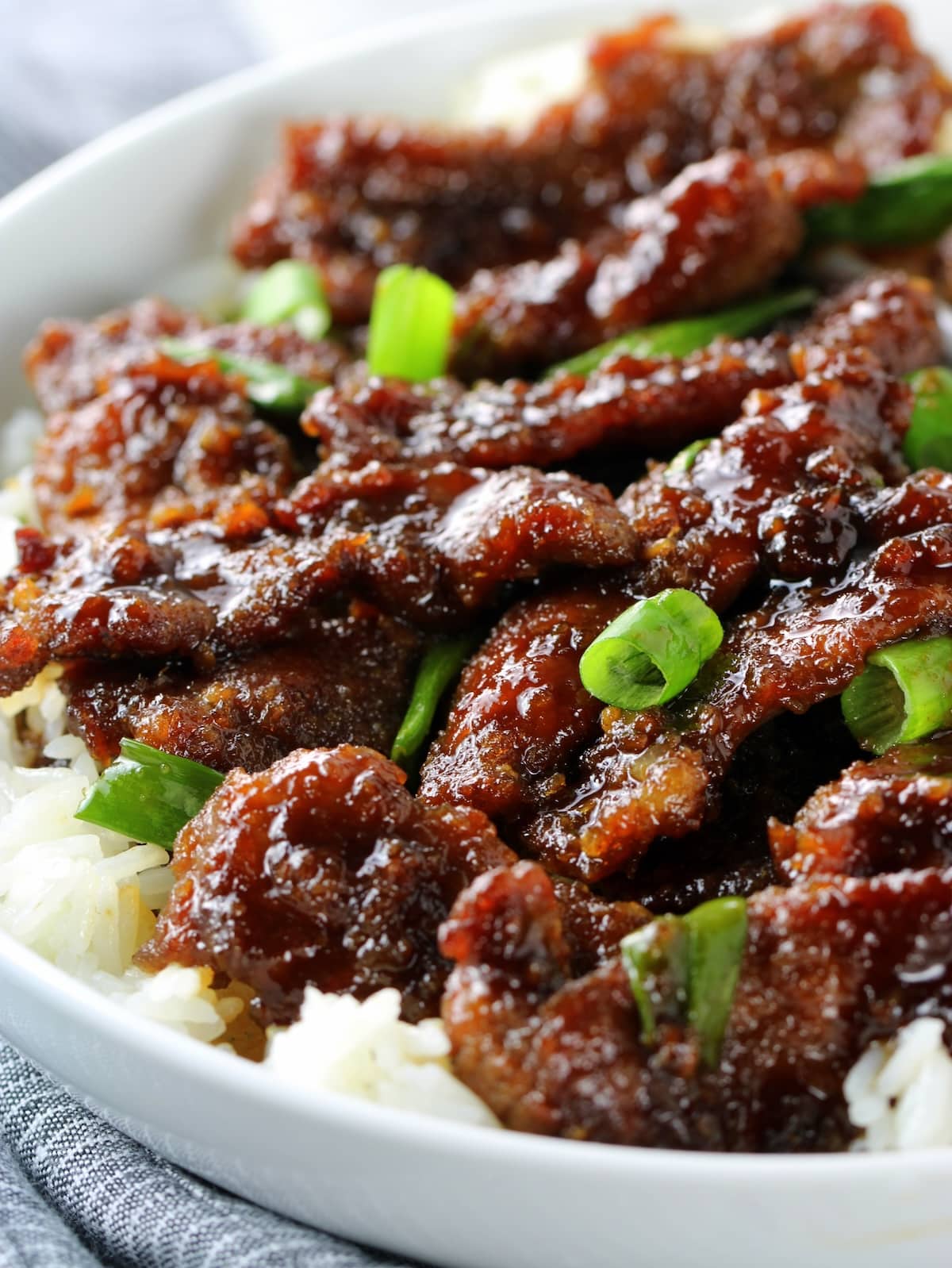 An eyelevel closeup photo of a plate with Mongolian beef.