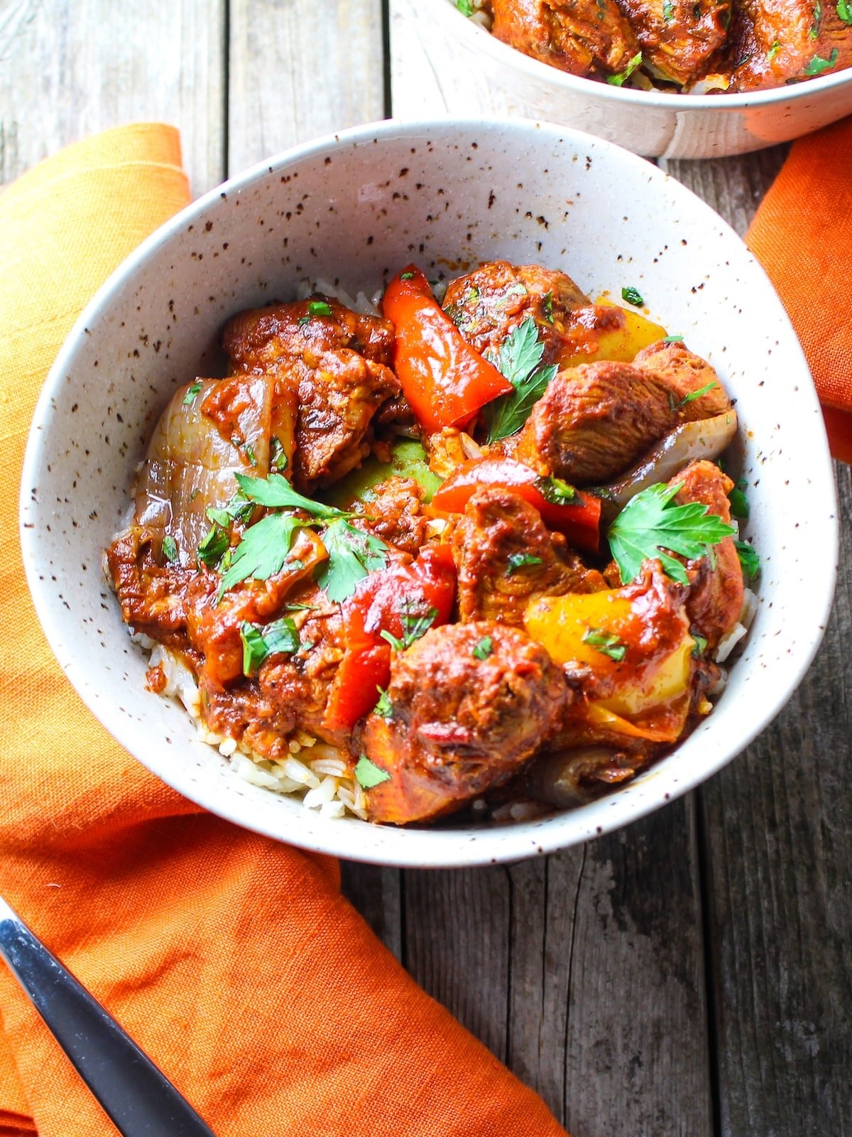 Bowls with rice topped with lemon harissa chicken, garnished with fresh parsley.
