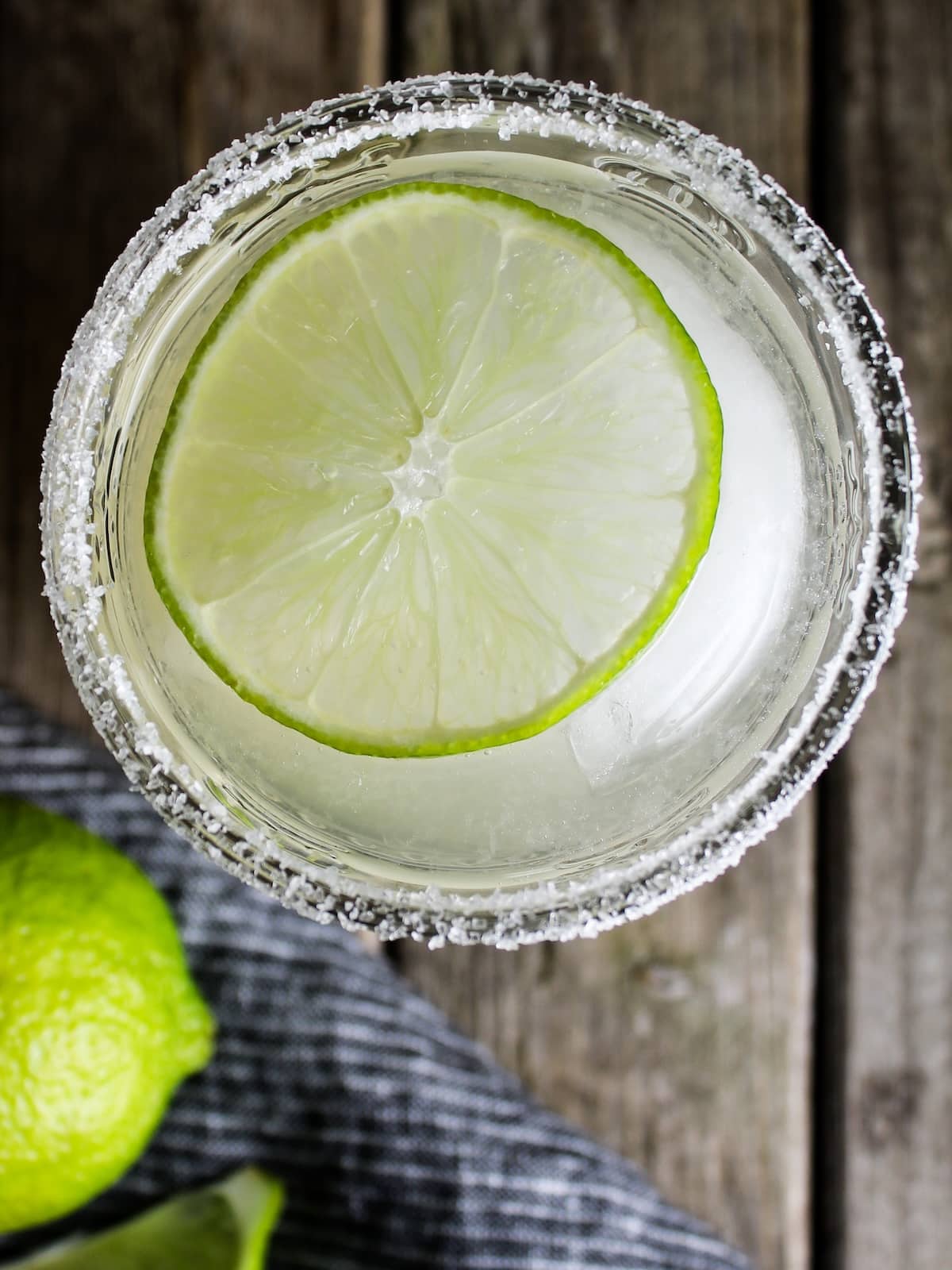 Elderflower Margarita A close-up over that top photo of a margarita with a salt rim and lime wheel.