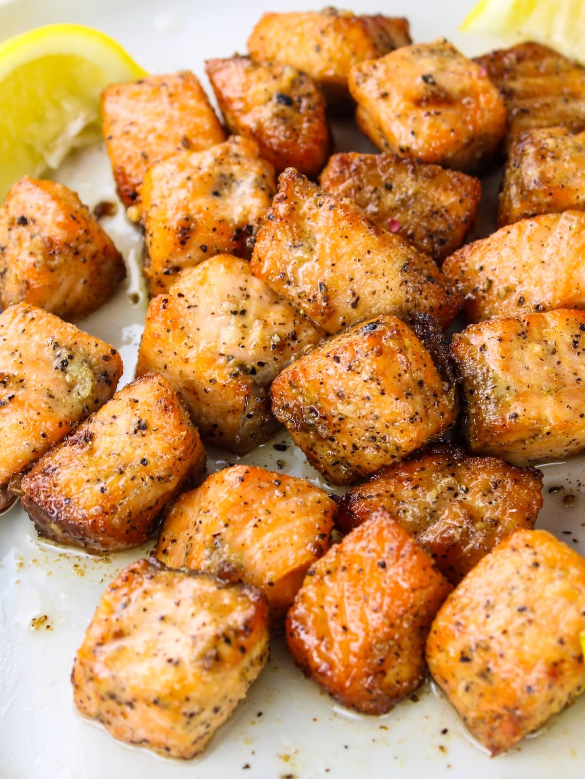 A plate with salmon fillets cut up and cooked in the air fryer.