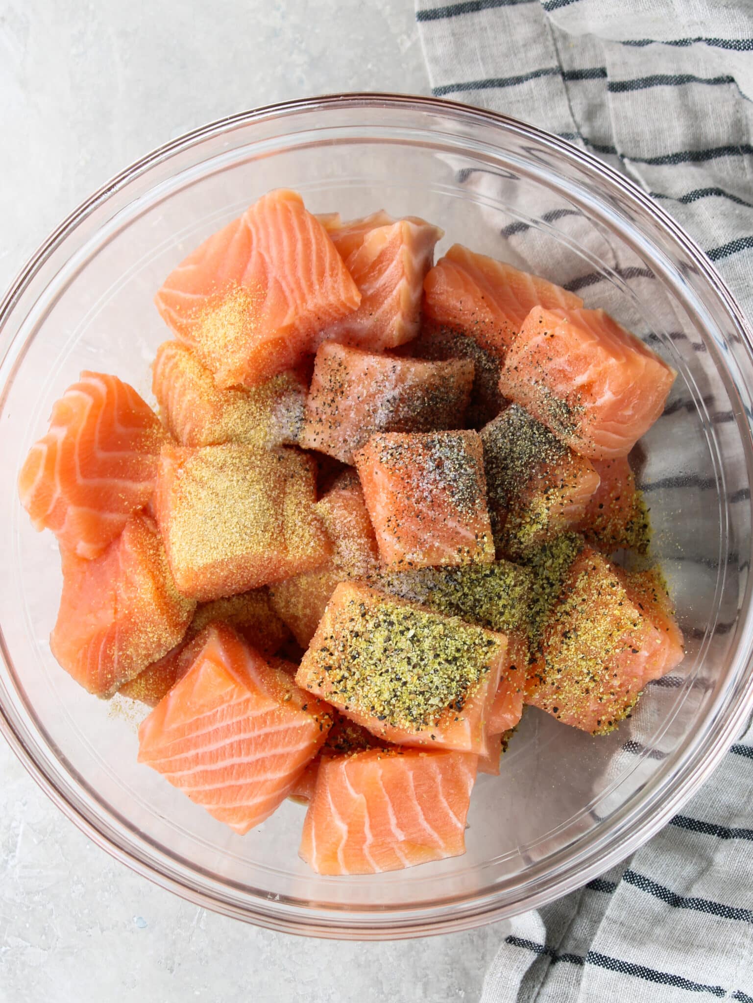 Salmon cut into cubes with seasonings added.