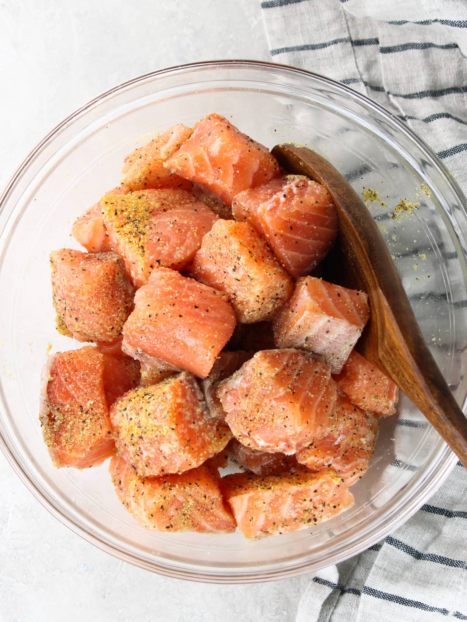 Air Fryer Salmon - seasonsings mixed into the raw, cut up salmon.