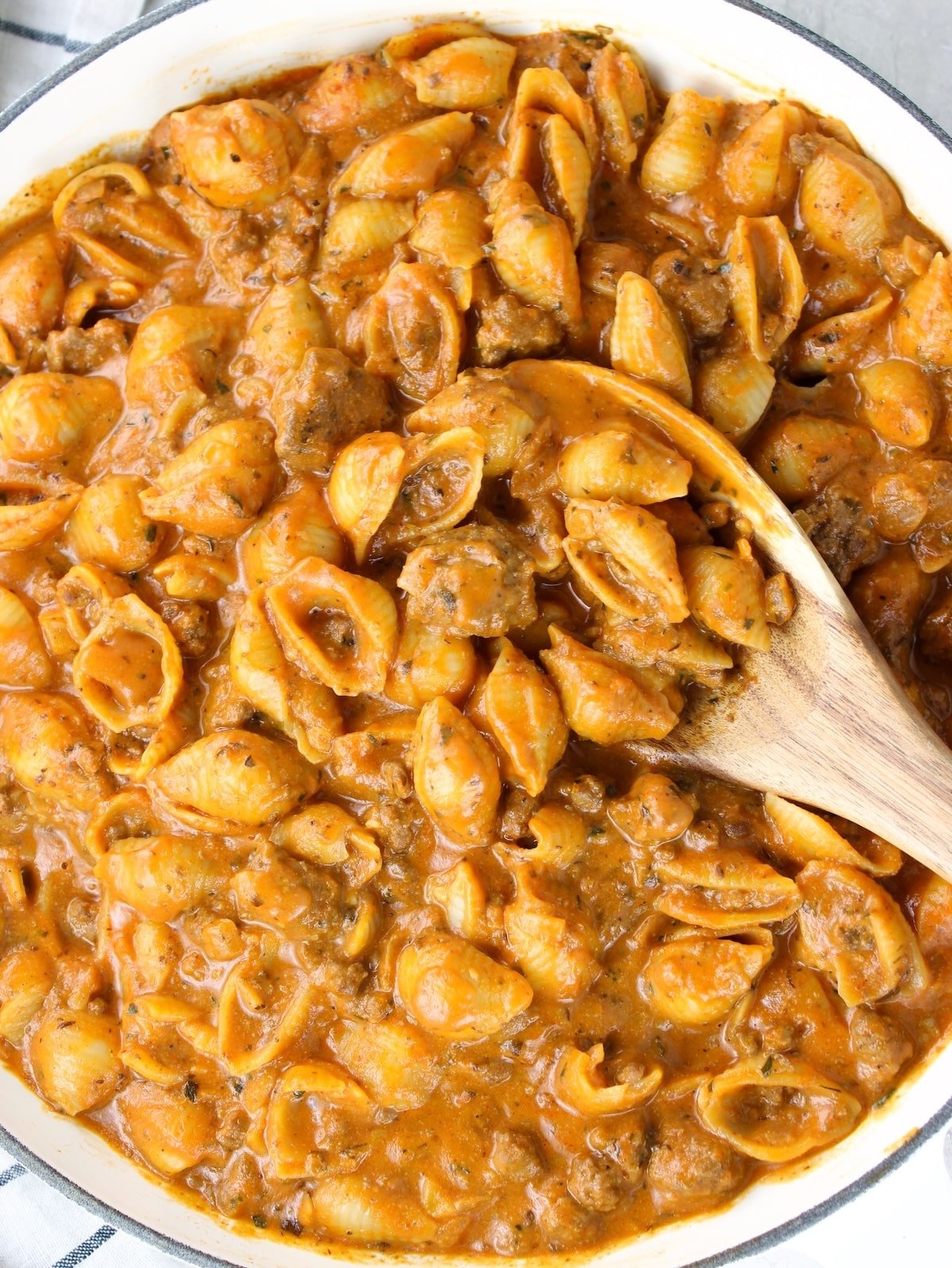 Creamy ground beef and shells in a skillet with a rich creamy tomato sauce.