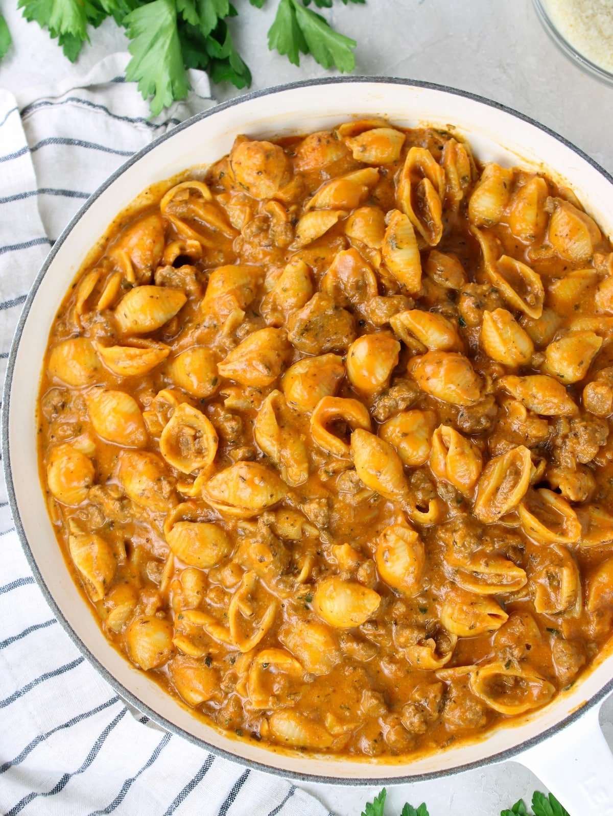 Creamy ground beef and shells in a skillet with a rich creamy tomato sauce.