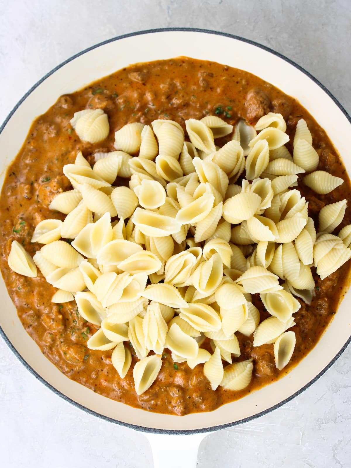 The beef and pasta being mixed together.