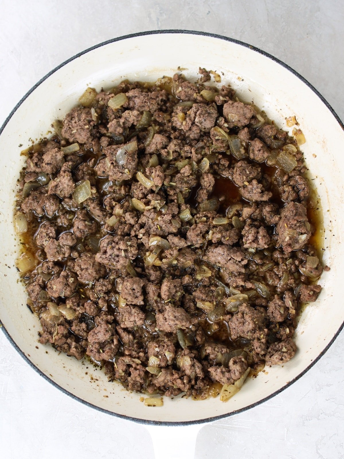 Cooking ground beef and Italian spices in the onion and garlic mixture.
