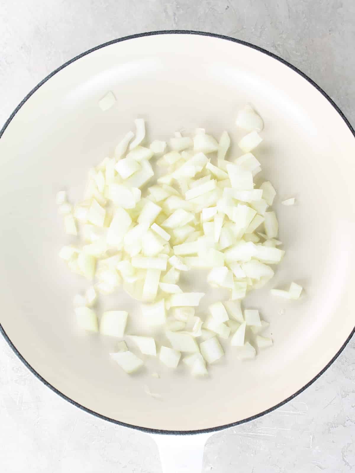 Sautéeing onions in a pan with olive oil.