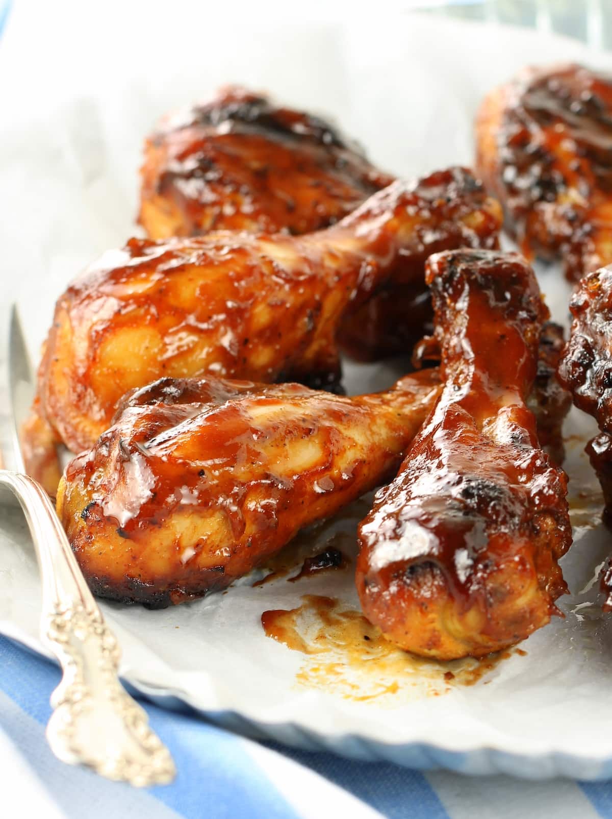Marinated and grilled BBQ chicken legs on a platter.