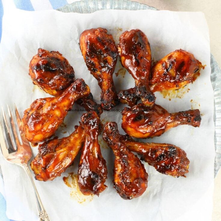 A platter of grilled BBQ chicken drumsticks ready to eat.
