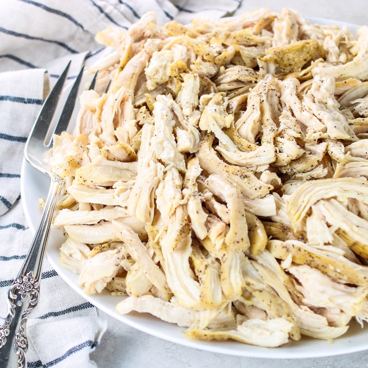 A photo of chicken breasts pulled on a platter.