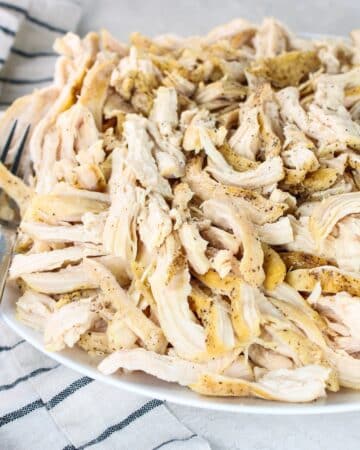 A platter with juicy shredded chicken breasts.