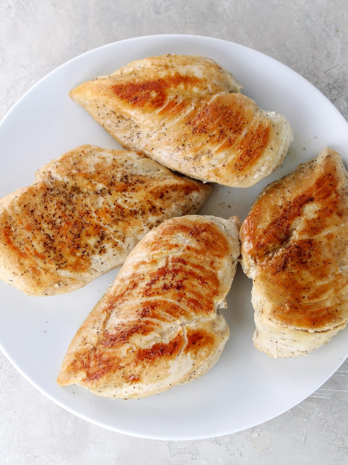 Seared boneless skinless chicken breasts ready to be added to the other ingredients and cooked in the crockpot.