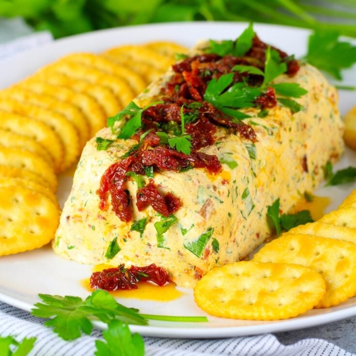 A cheese log with cream cheese, sour cream, bacon, sundried tomatoes, green onions, parsley and ranch seasoning.