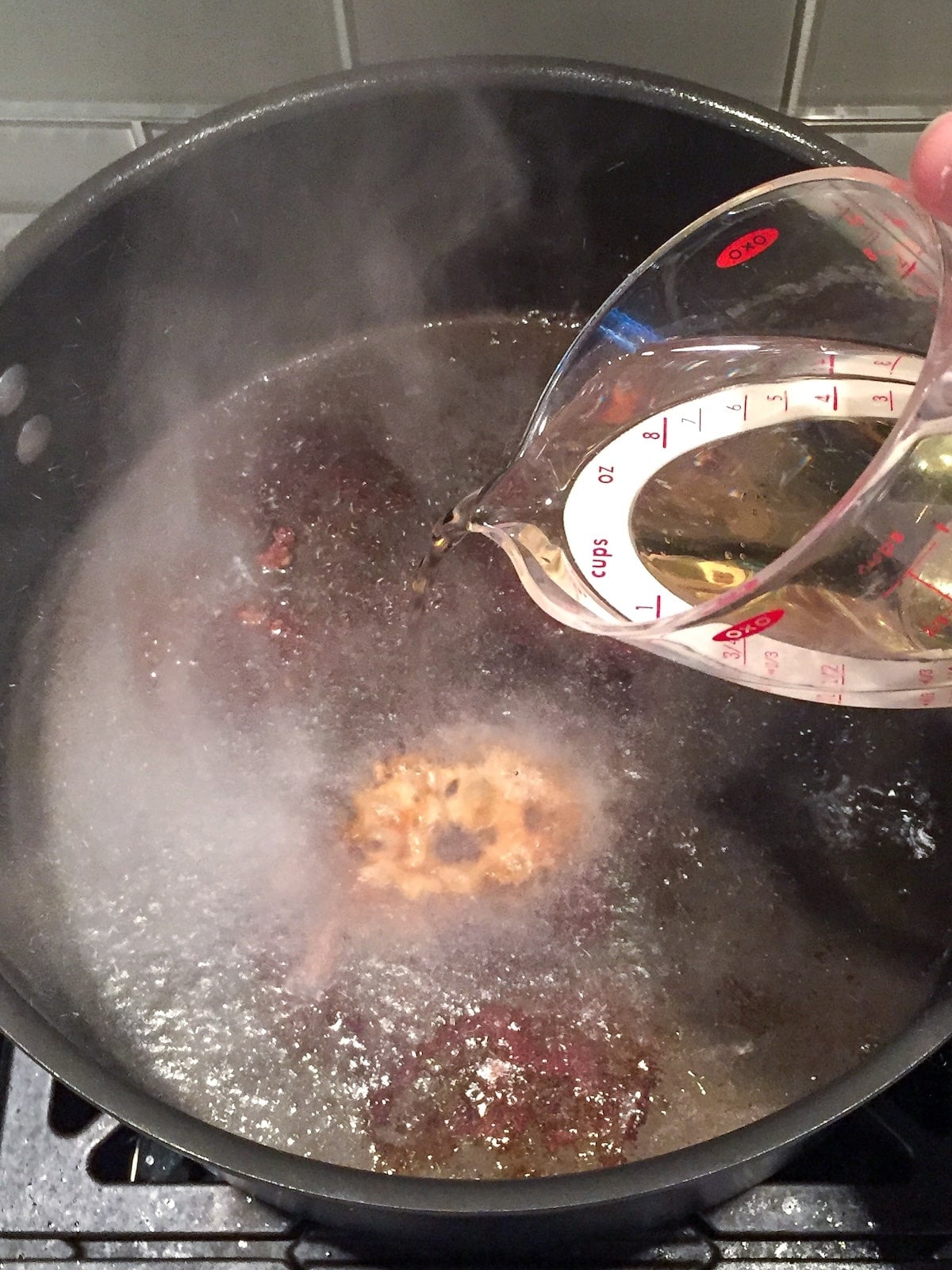 Deglazing the Dutch oven after searing the veal.