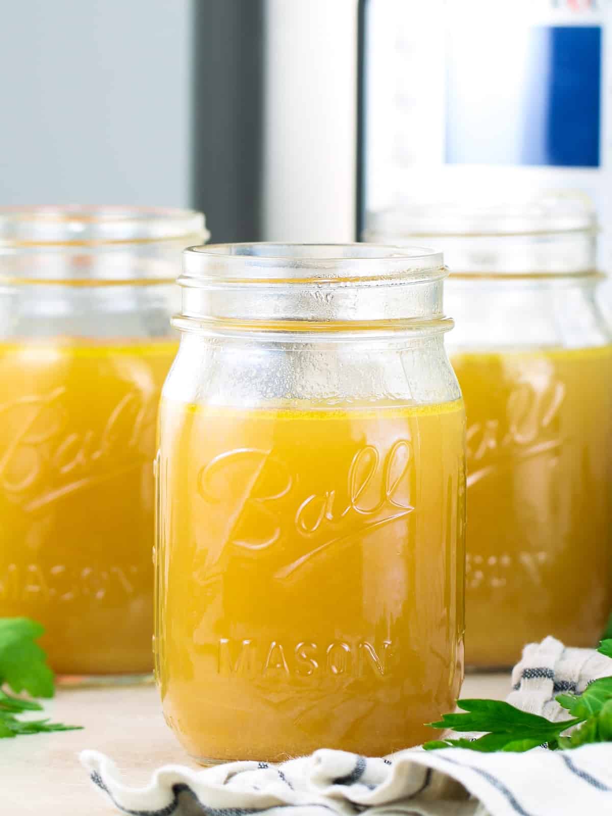 Instant Pot bone broth recipe - golden bone broth in glass jars.