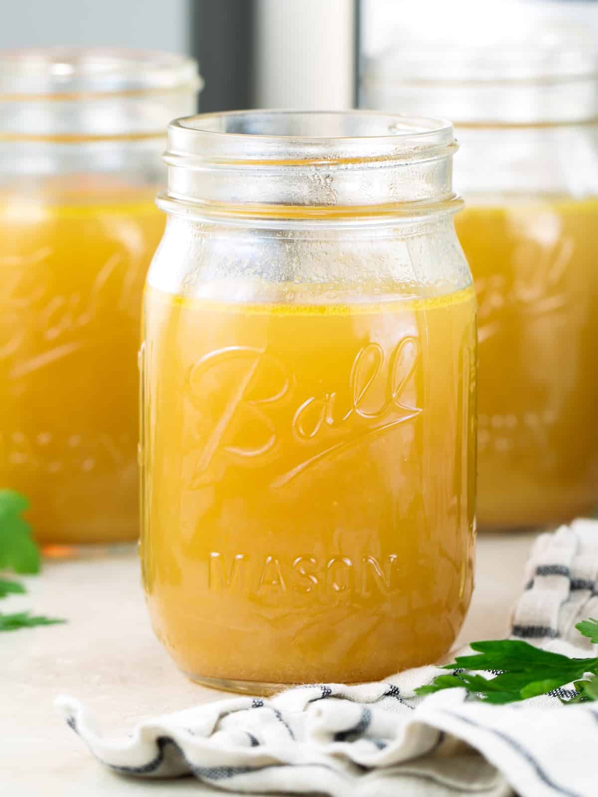 Instant Pot bone broth recipe — rich golden chicken bone broth in a glass jar.