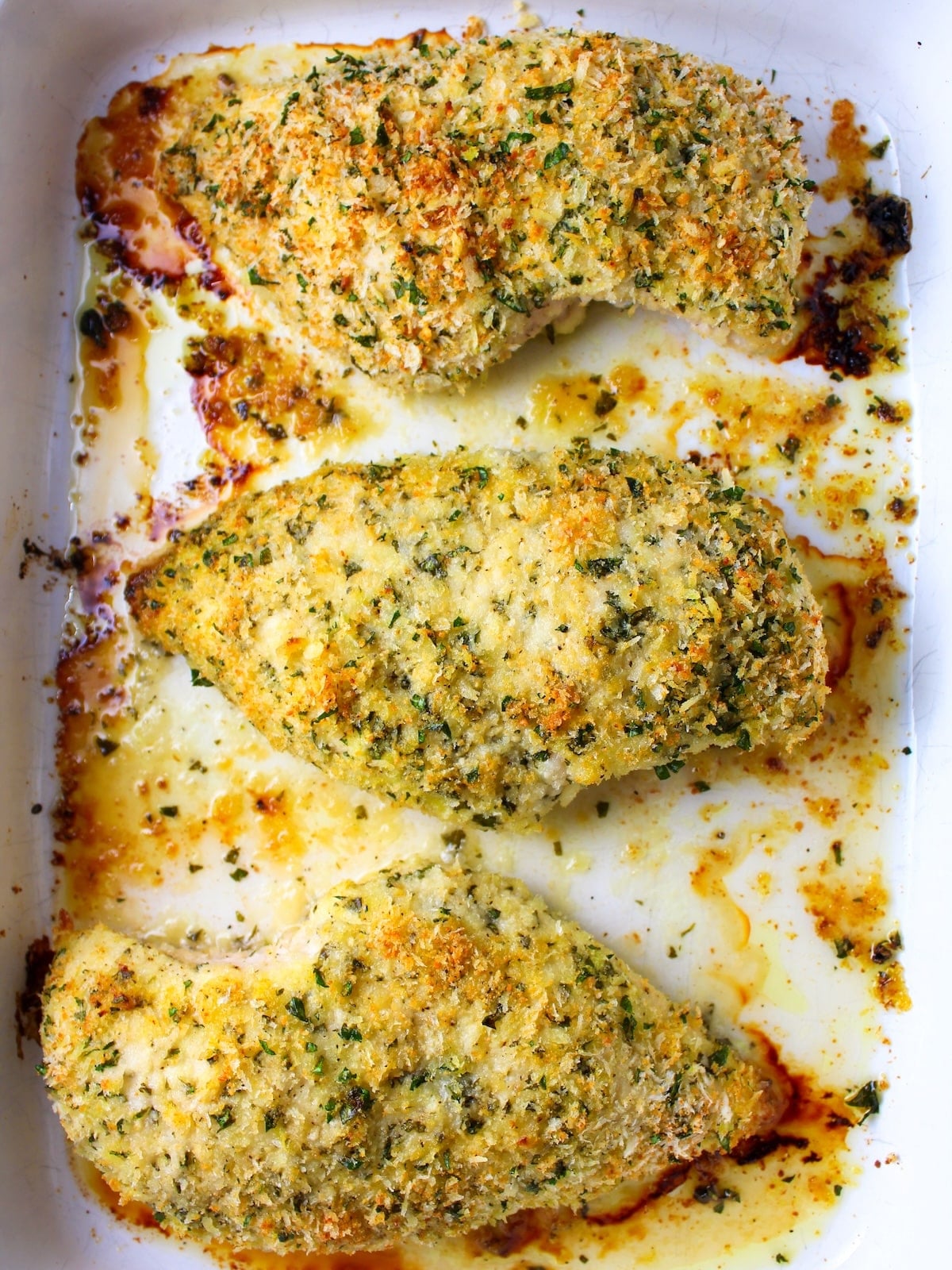 Oven-baked Parmesan crusted chicken breasts in a 9x13 dish.